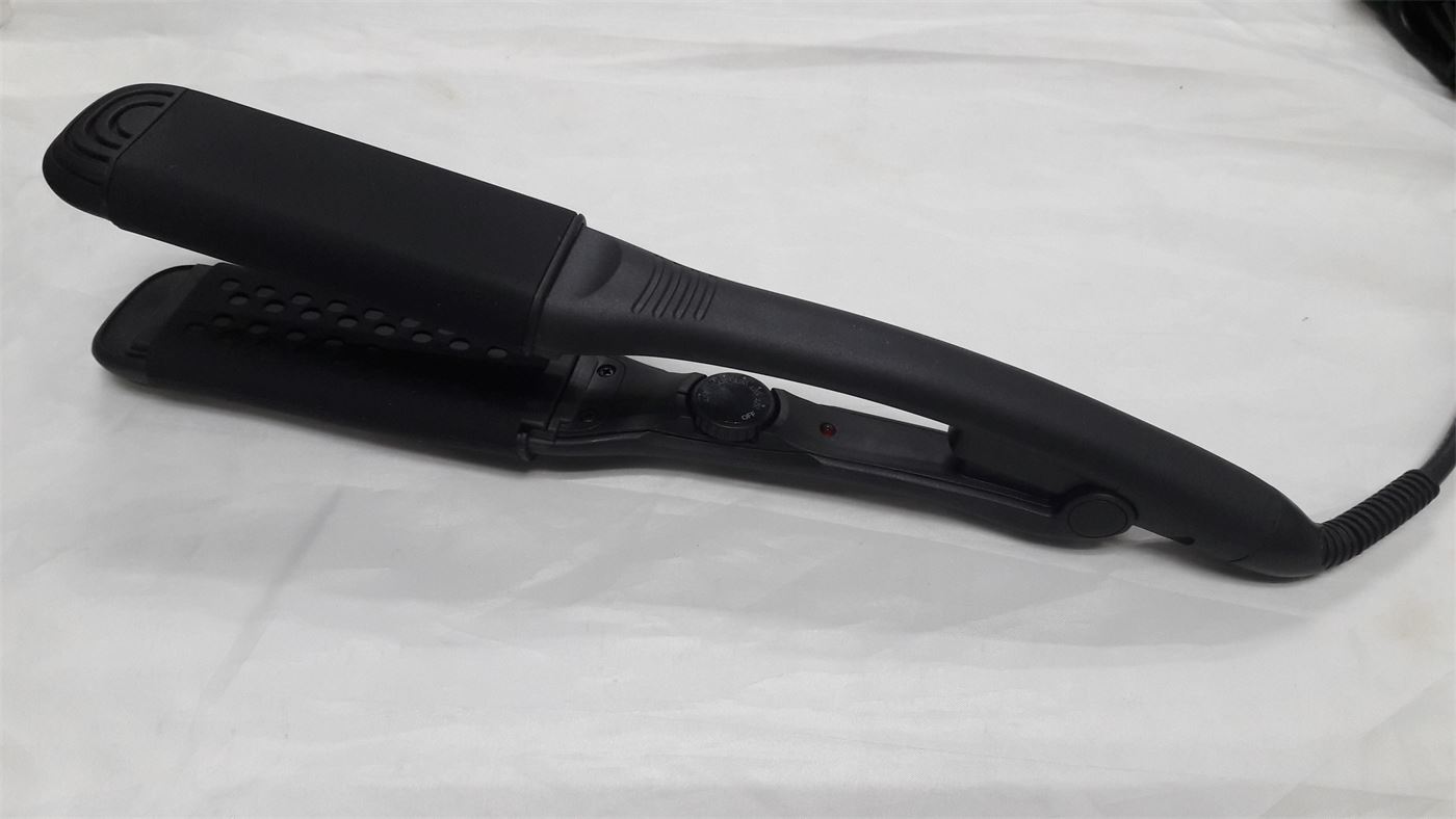 Black Steam Magic Styling Iron resting on a white surface